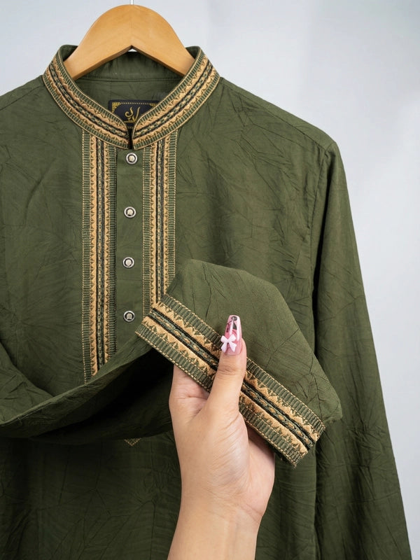 Green traditional outfit with intricate detailing on a hanger against a plain background