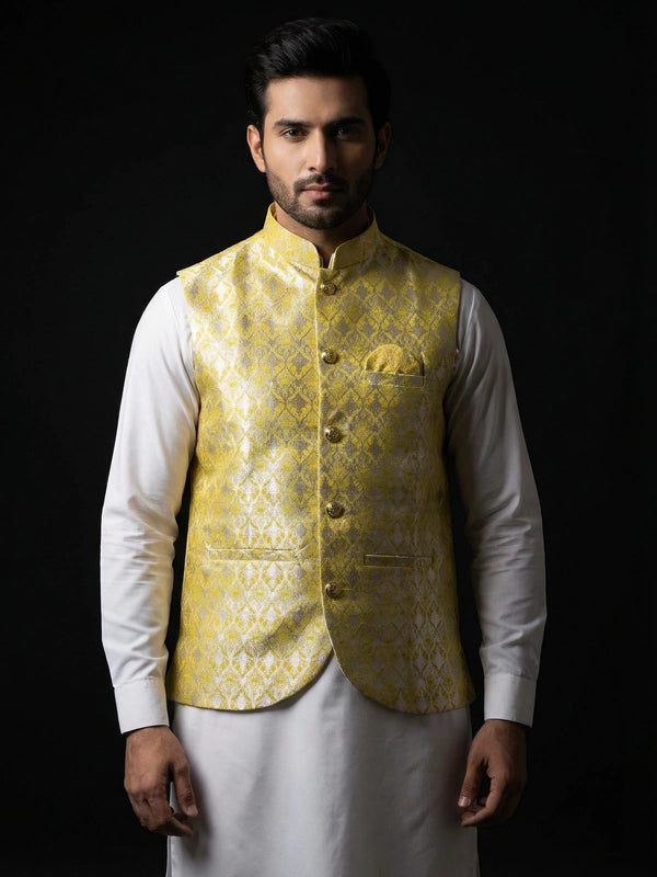 Man wearing a yellow embroidered vest over a white shirt on a black background